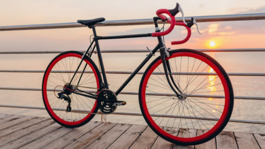 red and black bike on the wooden path near the sea and the sunset view